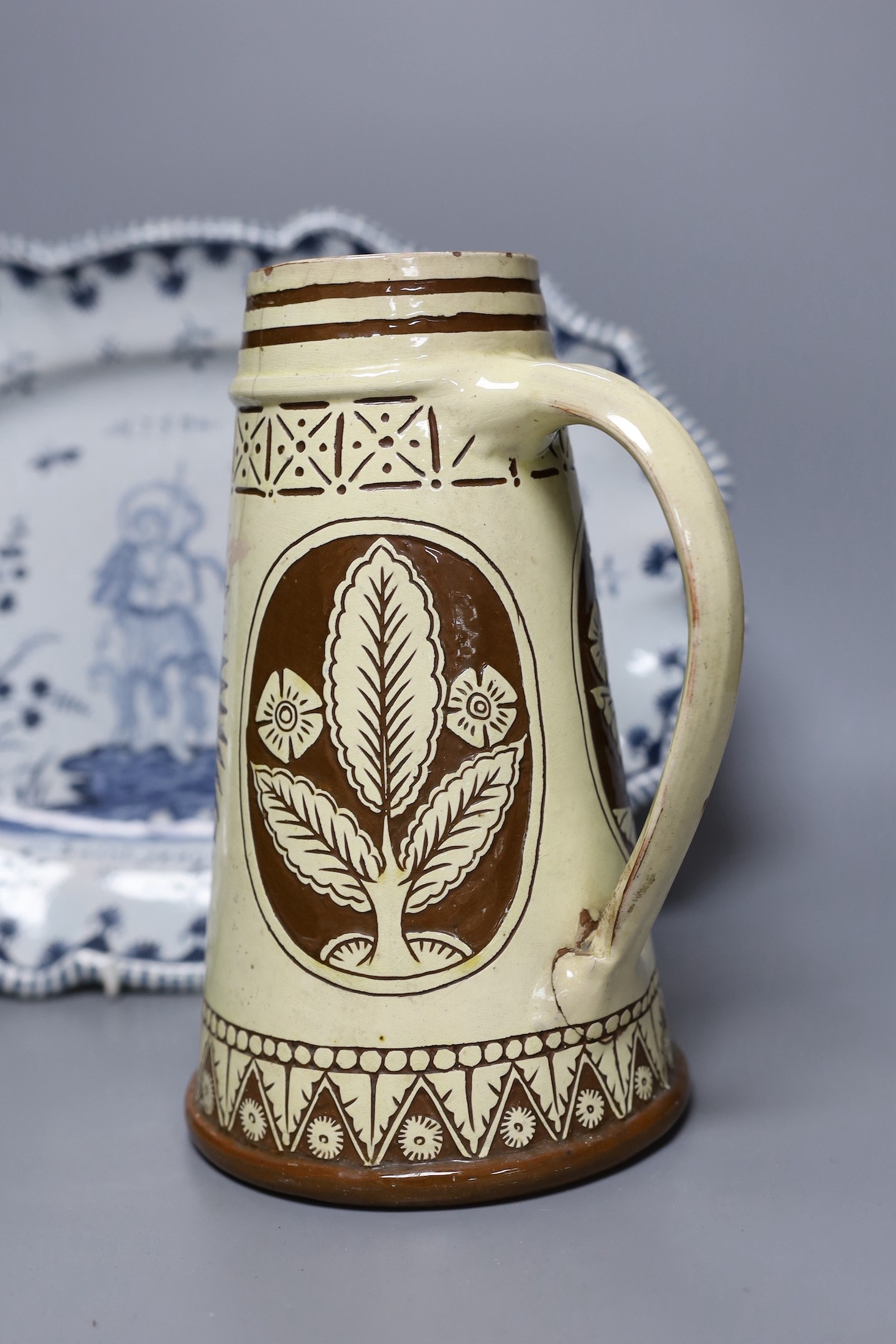 A Brannum sgraffito jug dated 1881 and a French faience serving dish, 42cm